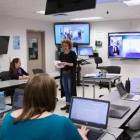 Une enseignante avec des étudiants en présentiel et à distance