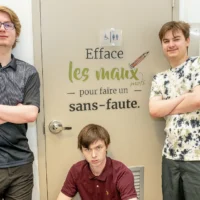 Des élèves devant une porte avec un slogan collé dessus