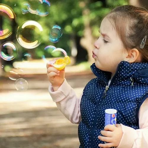 Une petite fille qui fait des bulles