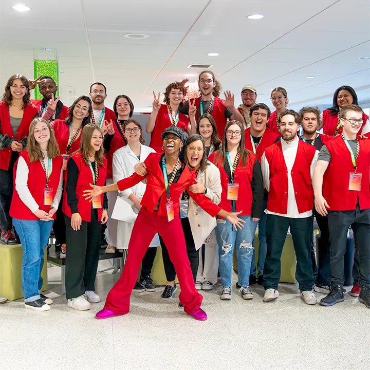 Des personnes étudiantes ambassadrices, reconnaissables à leur gilet rouge, sont réunies dans le hall d'entrée du Cégep de Matane pour une photo de groupe sur laquelle la bonne humeur et les sourires illustrent la bonne ambiance qui règne dans le groupe.