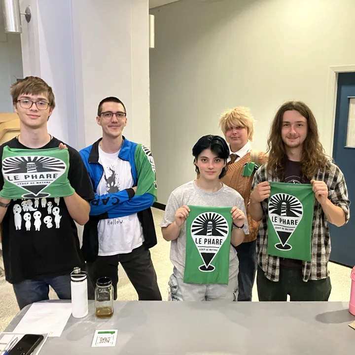 Des étudiantes et étudiants brandissent un cache-cou aux couleurs du Phare, zone d'aide du cégep dont le logo apparaît sur le vêtement.