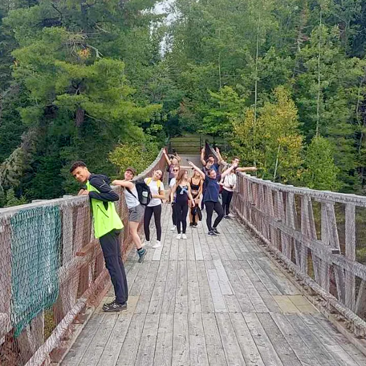 Des étudiantes et étudiants prennent la pose sur le pont suspendu du Canyon des portes de l'enfer, excités de se trouver dans un lieu aussi spectaculaire, au-dessus du vide.