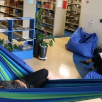 Personnes dans les hamac et coussins à la bibliothèque